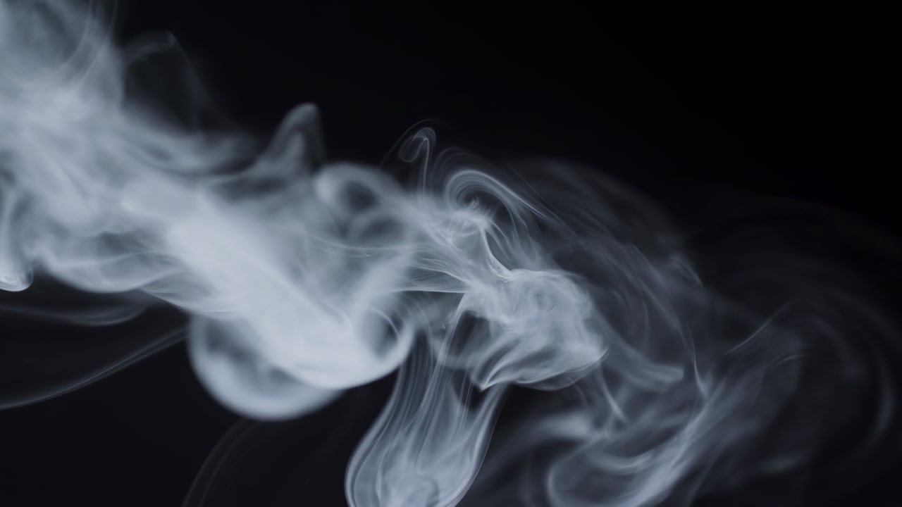 White Smoke Curling Across Black Background, Slowmotion Closeup Of Swirling Vapor And Wispy Tendrils,