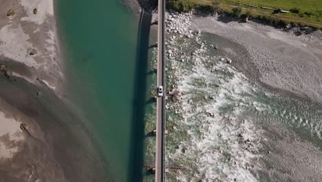 Auto-überquert-Eine-Einspurige-Brücke-über-Einen-Breiten,-Flachen-Fluss