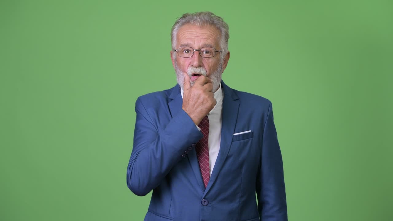 Affascinante uomo d'affari anziano con barba su sfondo verde