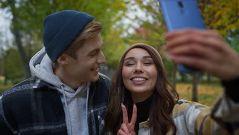 positive young lovers making funny faces on selfie outdoor. couple taking photo