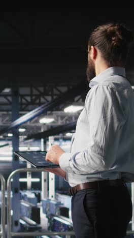 vertical video programmers on data center industrial platform checking code on tablet
