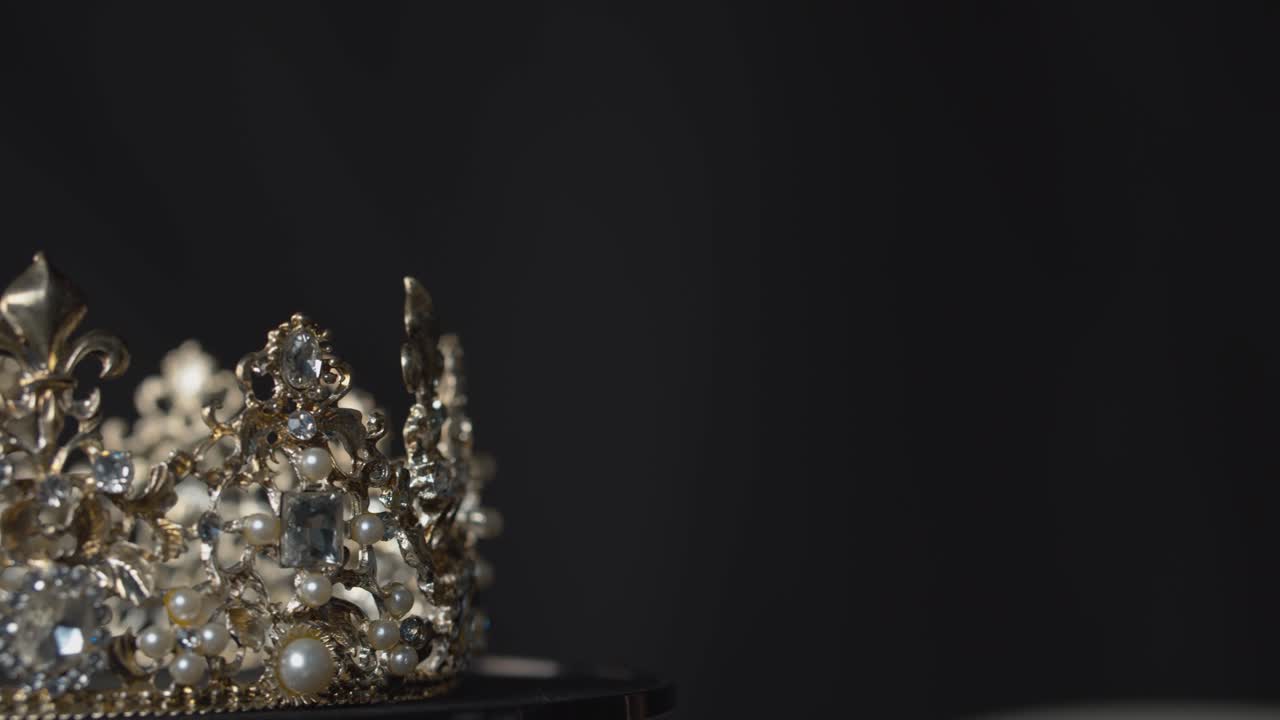 Amazing valuable crown for a royal queen, bride or beauty pageant winner on display on a turntable stand with copy space
