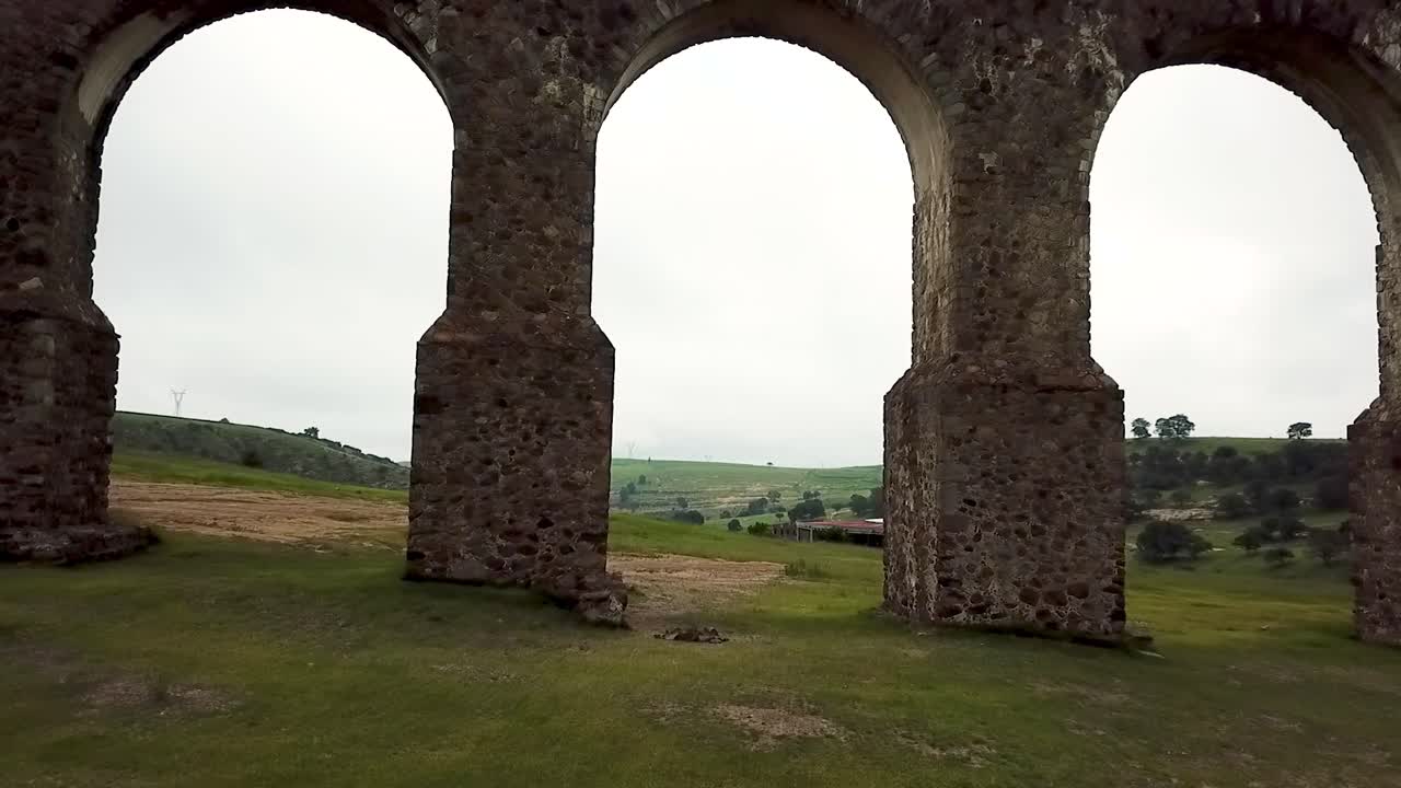 Drone shot crossing an arch in "Arcos del Sitio" in Tepotzotlan, State of Mexico, Mexico