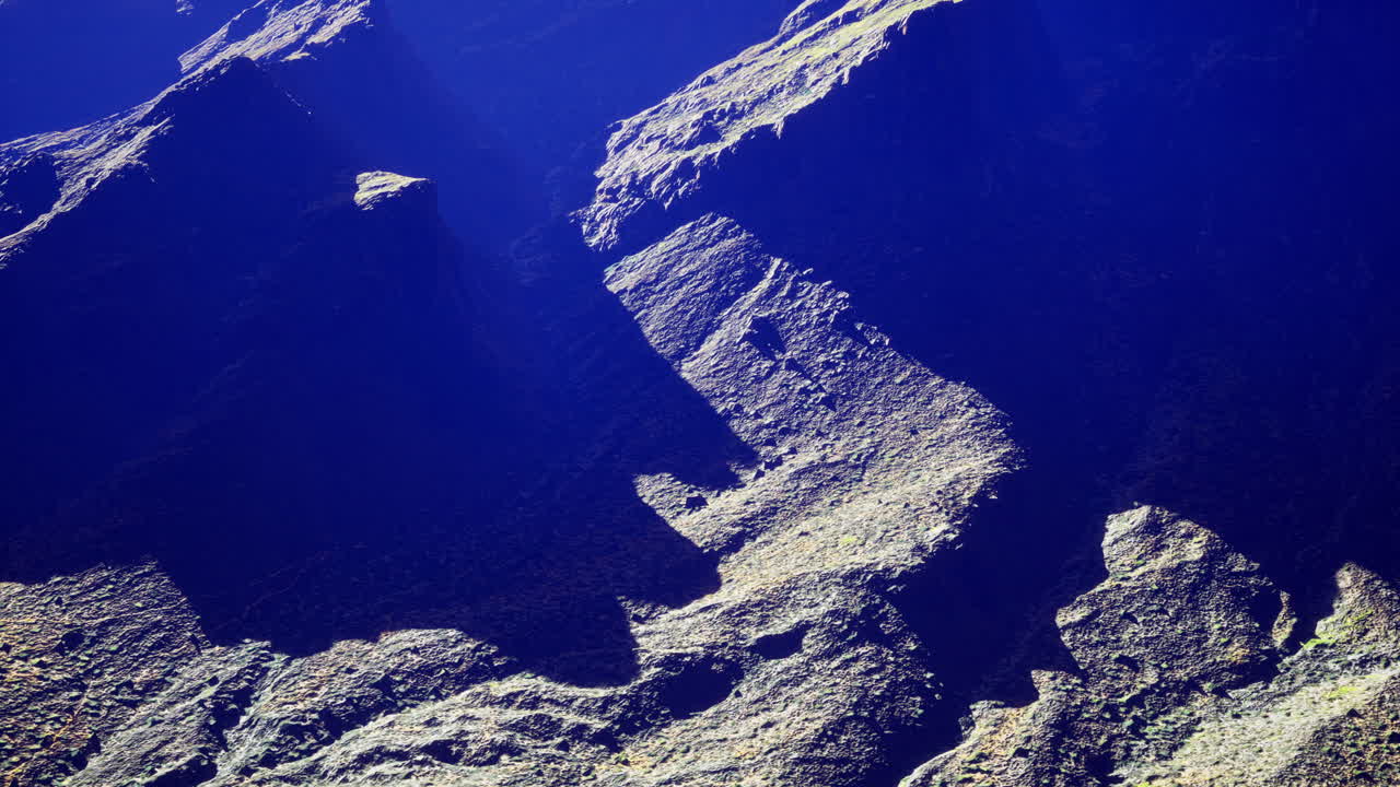 Unique rock formations with dramatic shadows under sunlight in a canyon