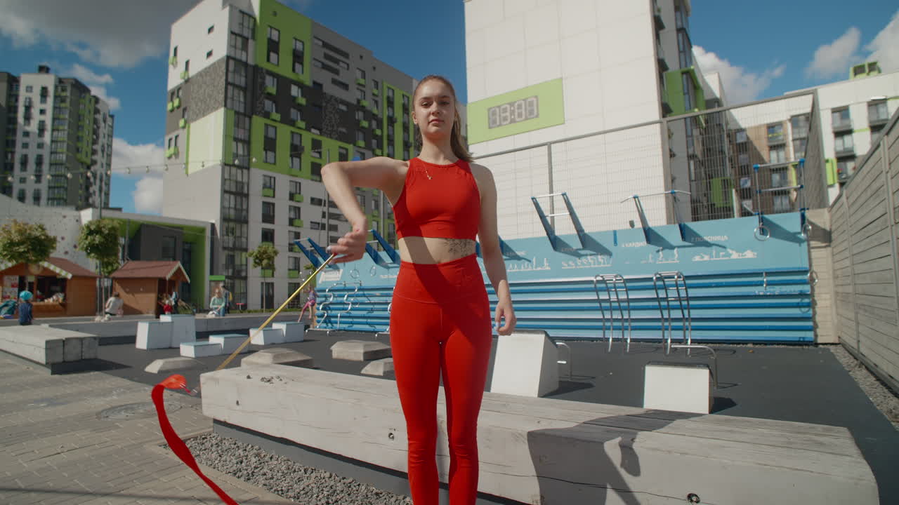 Woman Twirling Red Ribbons in Urban Setting