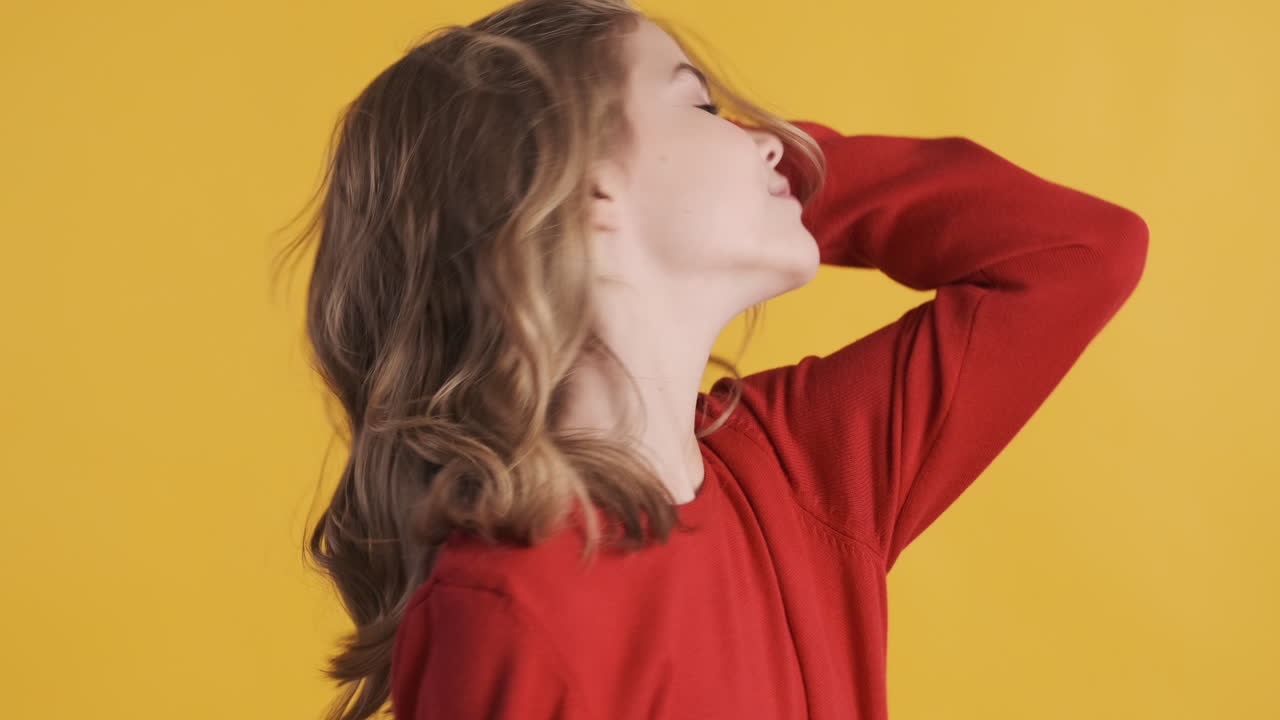 십대 백인 소녀가 카메라 앞에서 포즈를 취하고 미소 짓고 있습니다.