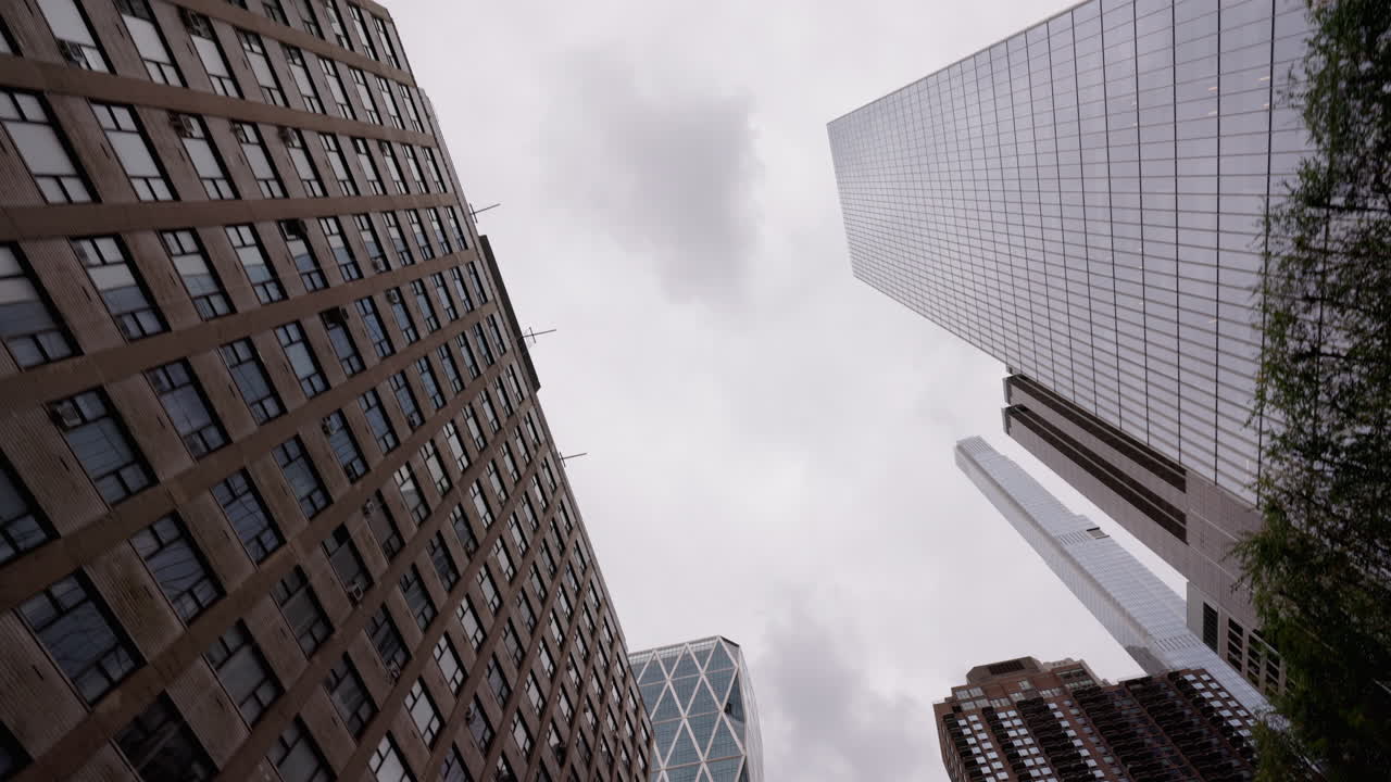 Visão em movimento de baixo ângulo entre arranha-céus em Manhattan, Nova York, arquitetura urbana e perspectiva dramática da cidade