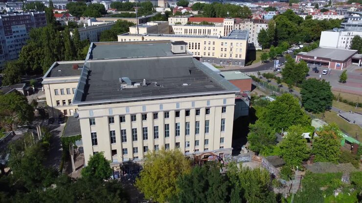 Filmato aereo con drone di un edificio a quattro piani, con un volo estremamente fluido in discesa e all'indietro, presso il club Berghain a Berlino Friedrichshain nell'estate 2022.
