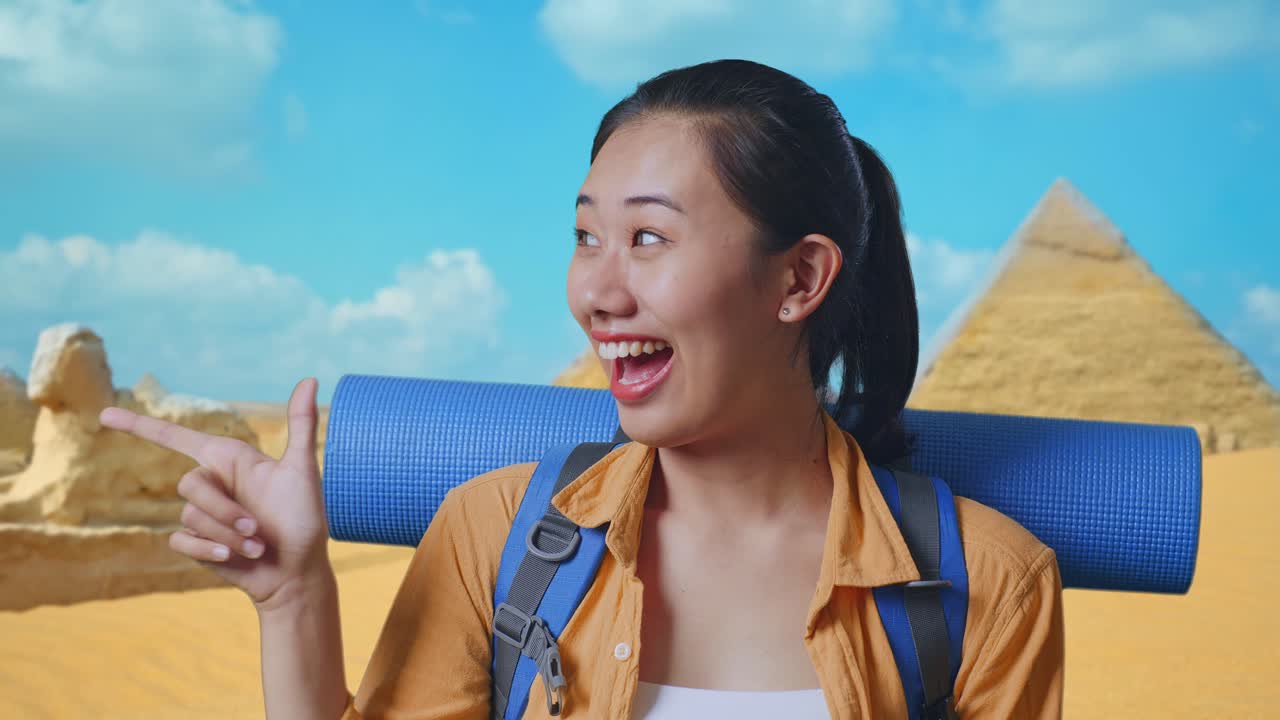 Close Up Of Asian Female Hiker With Mountaineering Backpack Smiling And Pointing To Side While Traveling In Pyramid Of Giza