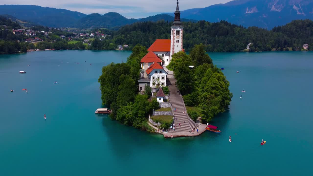 Close-up drone video of iconic island on Lake Bled with Church on sunny summers day - Lake Bled, Slovenia