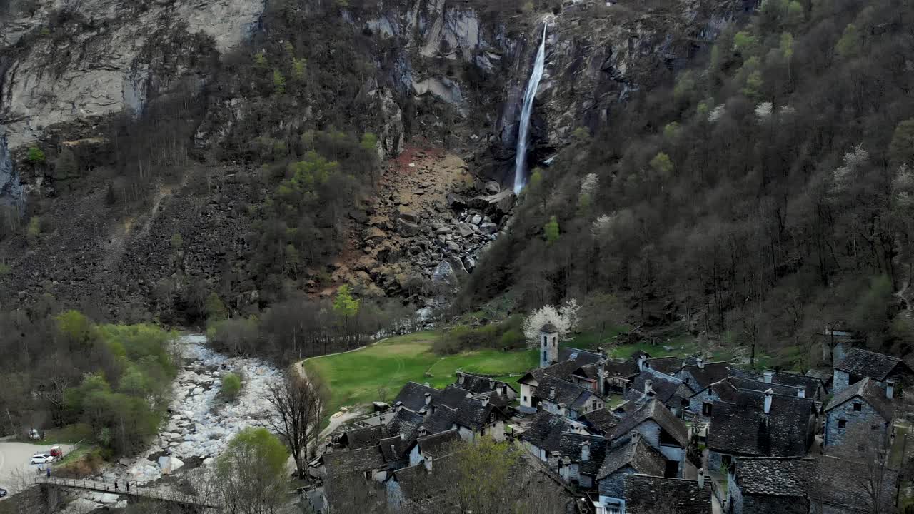 sobrevuelo aéreo sobre foroglio en ticino, suiza con vistas al pueblo con antiguas casas de piedra y cascada en el fondo al atardecer