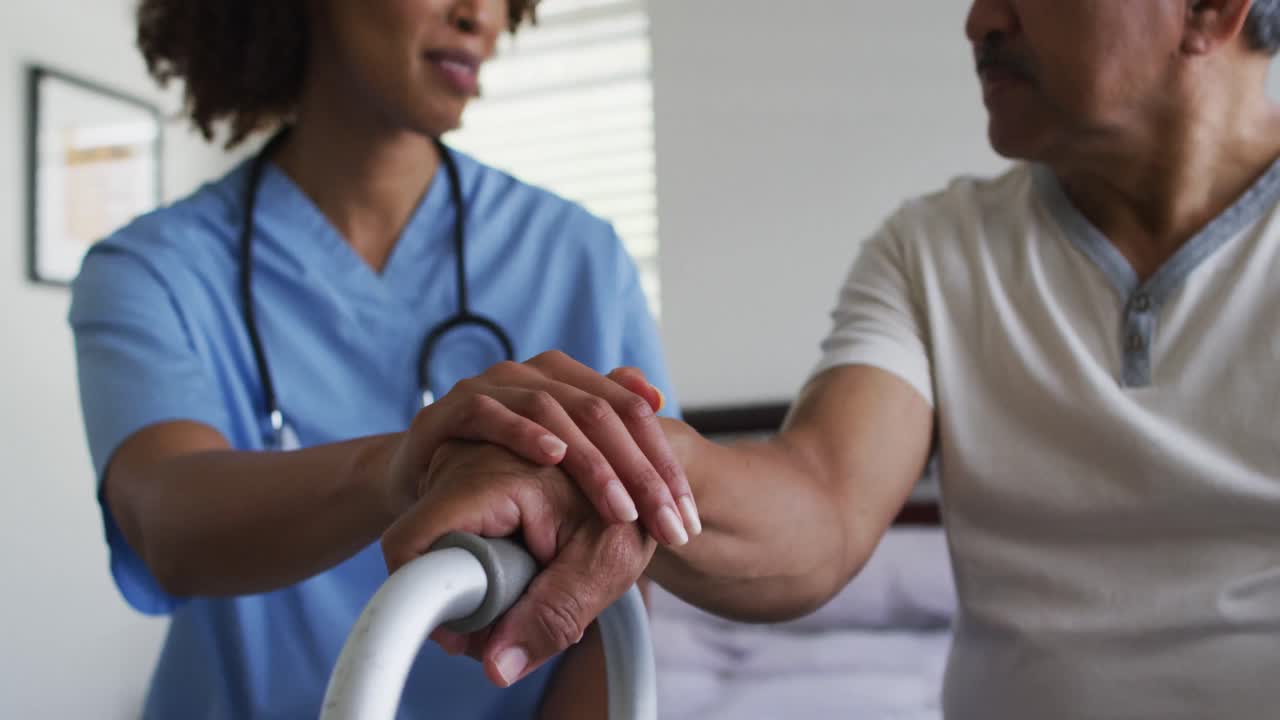 primer plano de un hombre de raza mixta con una doctora visitando la casa tomados de la mano
