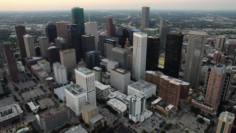 aerial tracking shot of the downtown houston skyline, colorful dusk in tx, usa