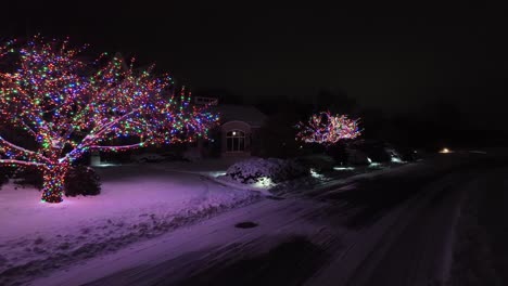 multi colored christmas lights on trees at large residential home in usa during holiday season