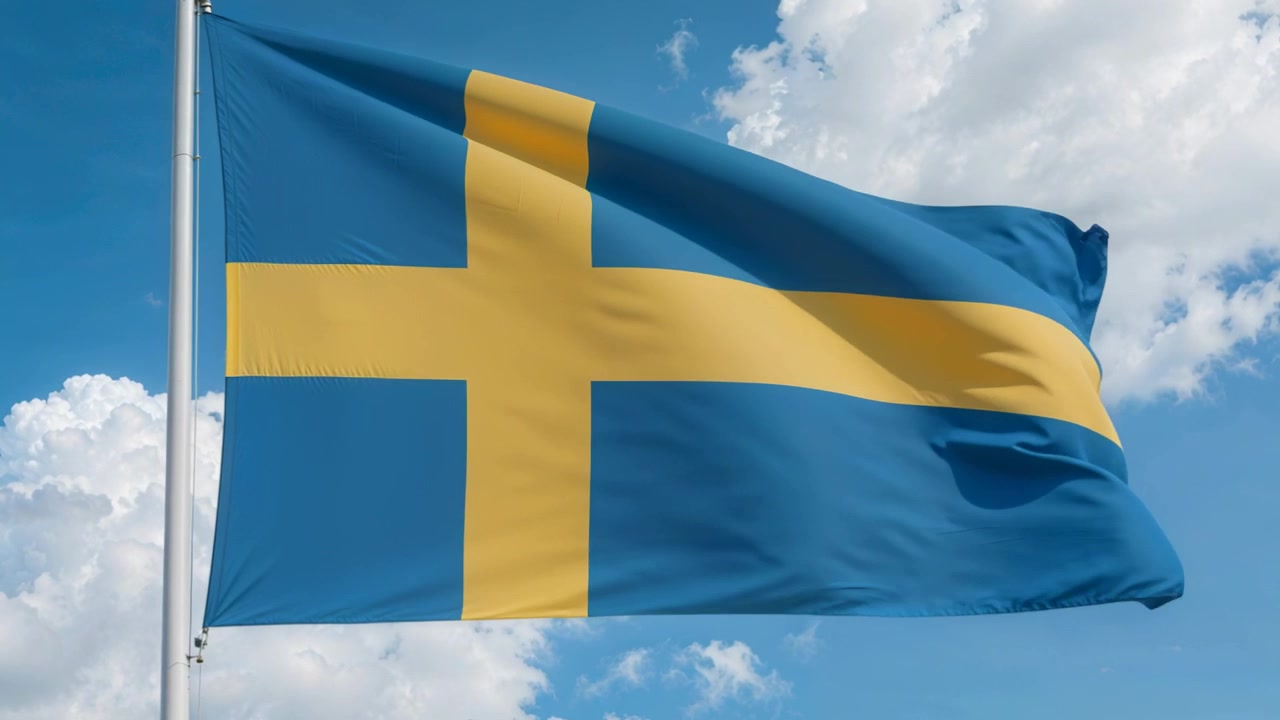 Et vajende svensk flag på en stang reagerer på vindstød udenfor under en overskyet himmel og afslører et gult kors.
