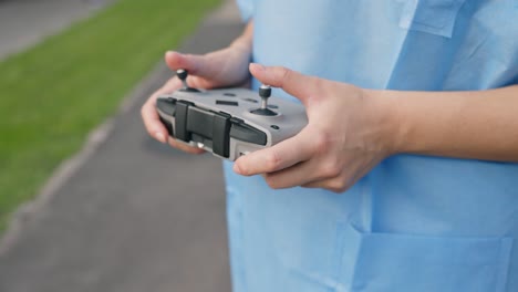 close-up of young female hands operating drone remote controller