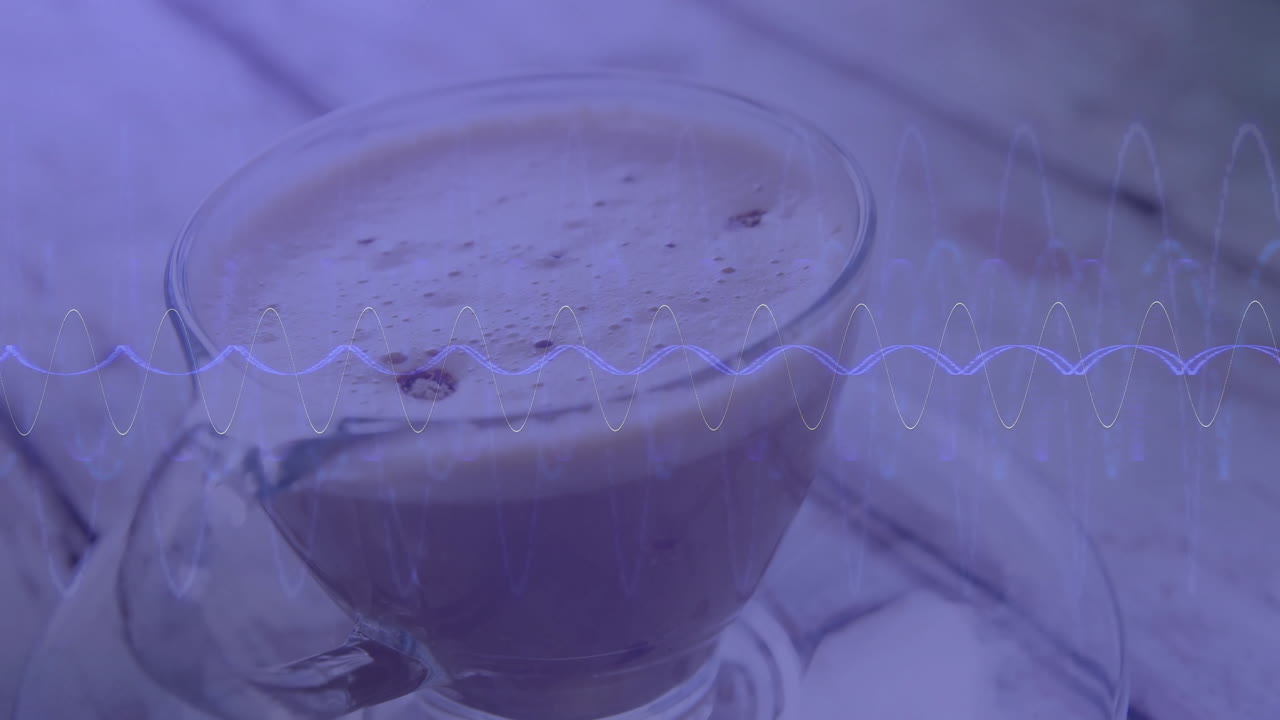 Tazza da caffè in vetro trasparente che mostra un cappuccino schiumoso su un piano del tavolo con un overlay digitale a forma d'onda.