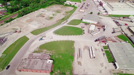 Vista-Aérea-De-Semirremolques-Con-Remolques-De-Ganado-En-Zona-Industrial-Rural.