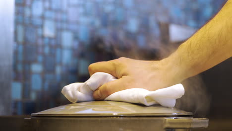 el chef quita la tapa de la olla mientras cocina mejillones frescos