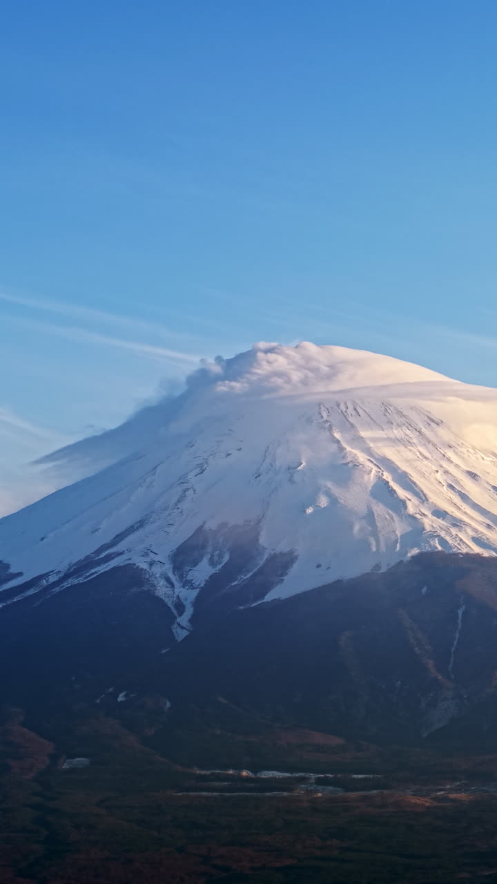 Aerial drone view of Mount Fuji with snow at the top in daylight. Vertical
