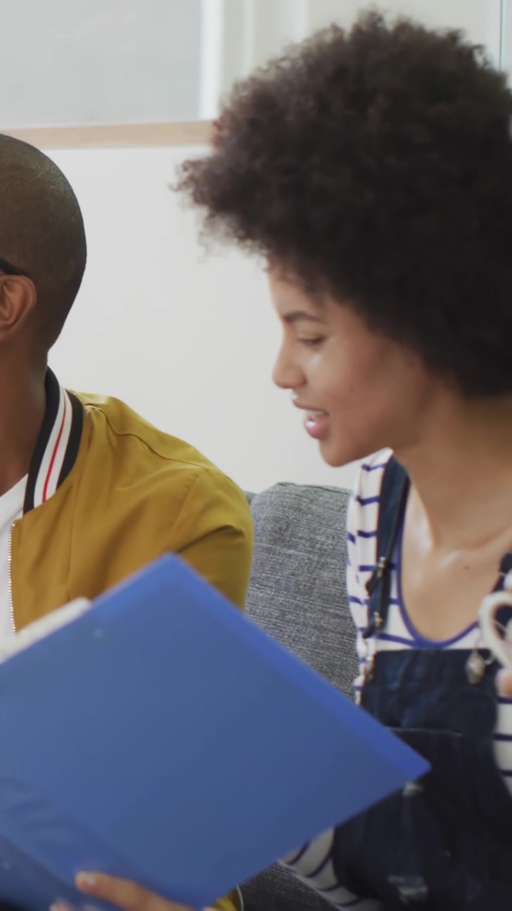 Vertical video: Woman flipping blue binder and speaking, likes accumulating and driving marketing