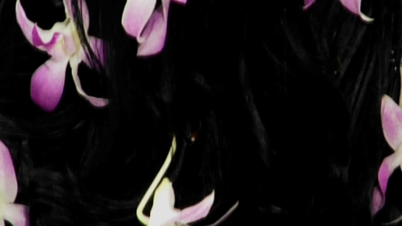 머리에 꽃이 달린 비키니 탑을 입은 여자가 등을 대고 누워 있다