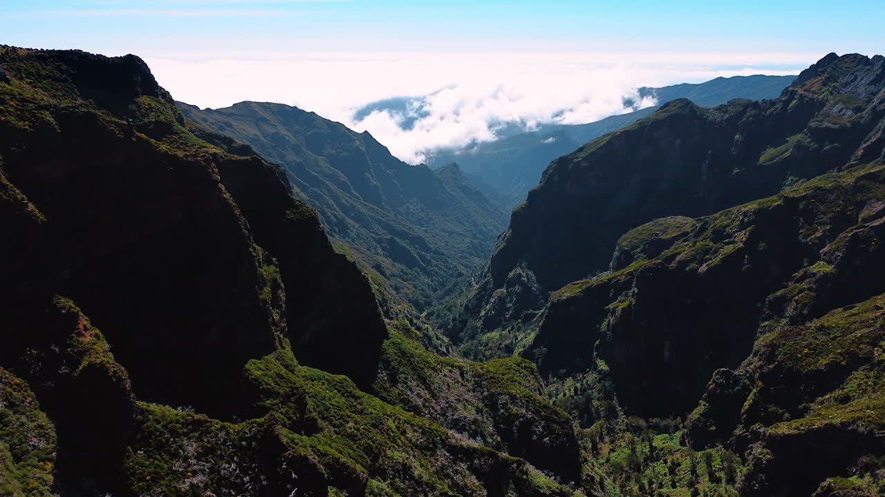 Flight among the stunning rocks of Madeira, Portugal. Sunny view of unapproachable mountains covered with mosses and lichens.