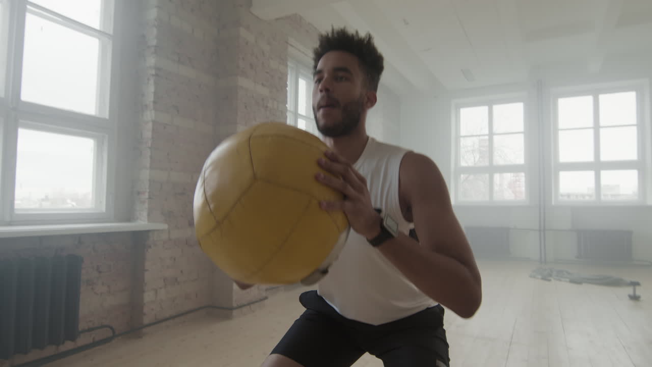 Young Black Sports Man Doing Squats Indoors
