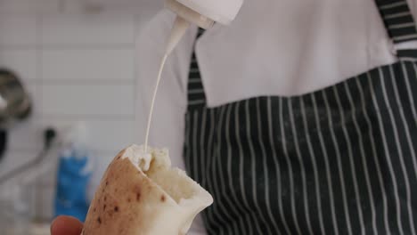 Koch-Legt-Tahini-In-Fladenbrot,-Aufnahme-Bei-100-Fps-2