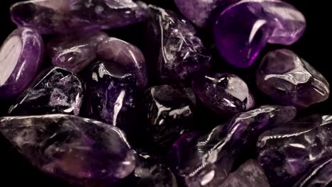 close-up video of polished amethyst stones with shifting light, highlighting their rich purple hues and smooth textures