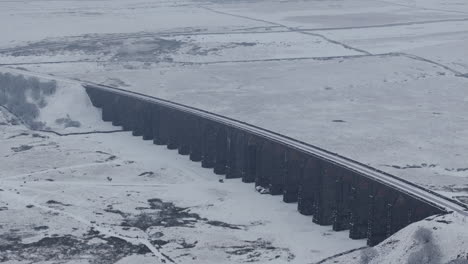 Retroceso-Estableciendo-Una-Toma-Aérea-De-Un-Drone-Del-Viaducto-Nevado-De-Ribblehead-En-Los-Valles-De-Yorkshire-En-Un-Día-Sombrío-En-El-Reino-Unido