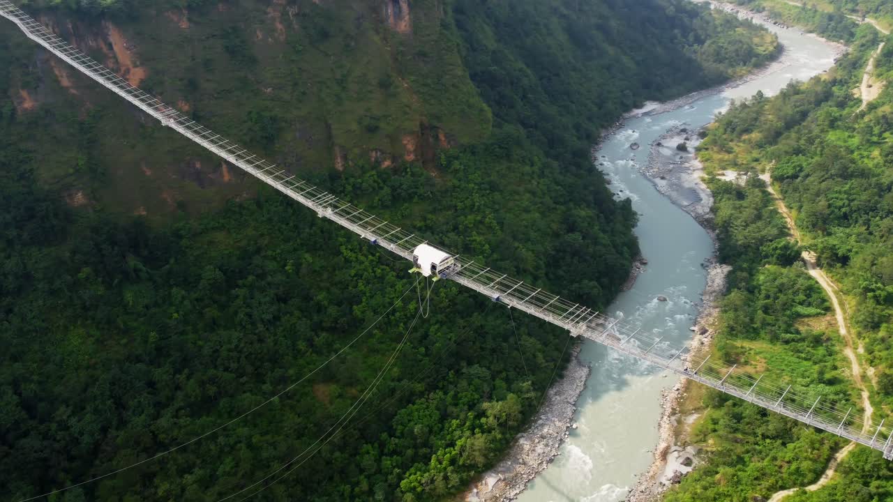 Kushma bungee jumping off suspension bridge high above ravine