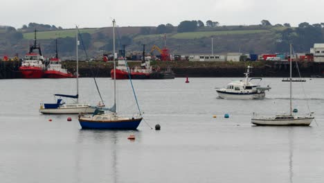 wide shot of falmouth marina with docks in background with boat passing through frame