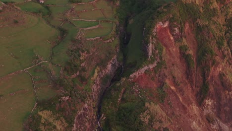 Luftaufnahme-über-Dem-Dorf-Mosteiro-Mit-Hoher-Klippe-Auf-Den-Azoren-Von-Flores