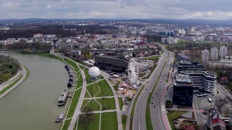 aerial shot of city highway, ferris wheel and urban scenery