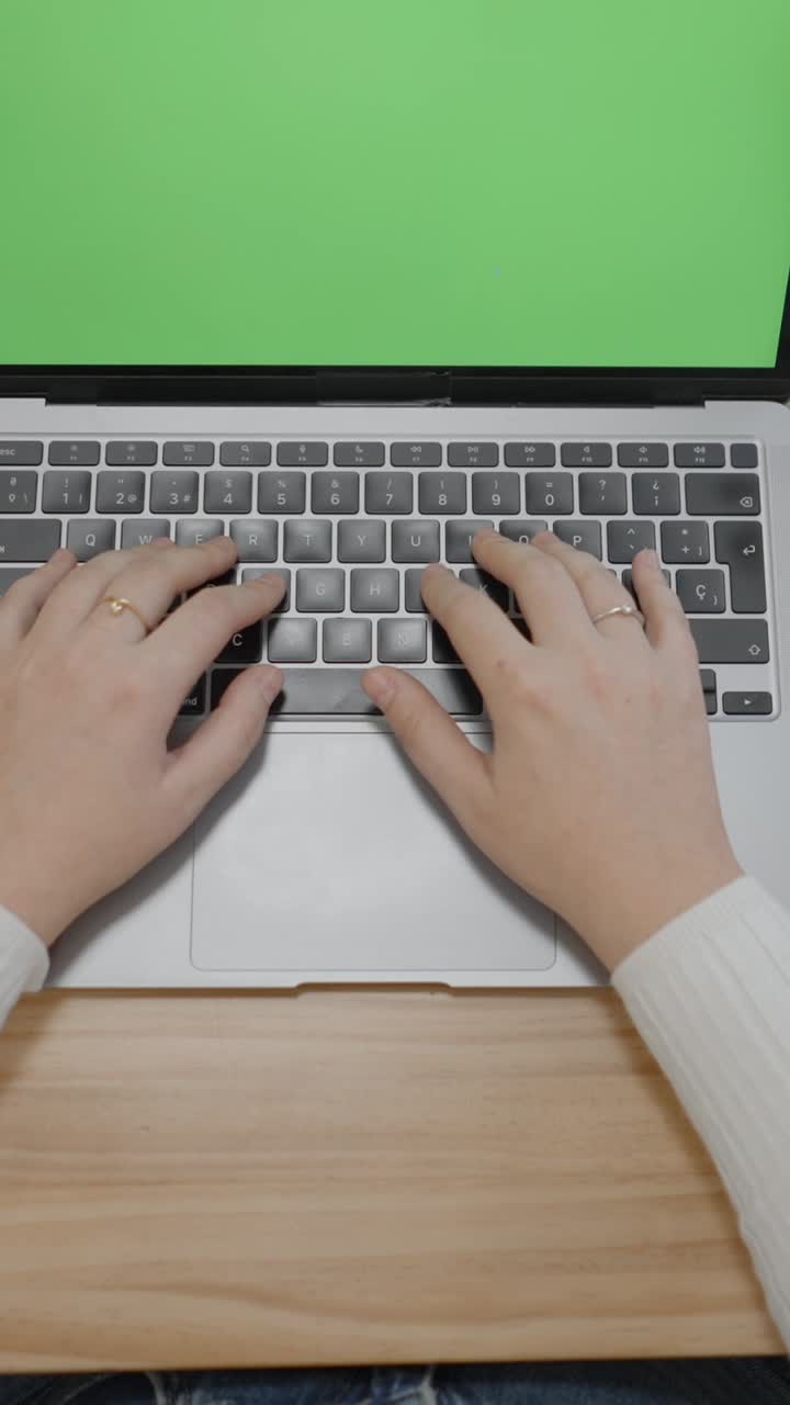 persona escribiendo en una computadora portátil con pantalla verde