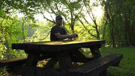 El-Hombre-Se-Acerca-Y-Se-Sienta-En-Una-Mesa-De-Picnic