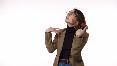 Portrait-of-young-woman-in-jacket-and-jeans-shows-how-hot-it-is-with-hand-gestures-on-an-isolated-white-background-looking-to-the-sides.-Confused-and-irritated.-Copy-space.-The-emotions-of-people