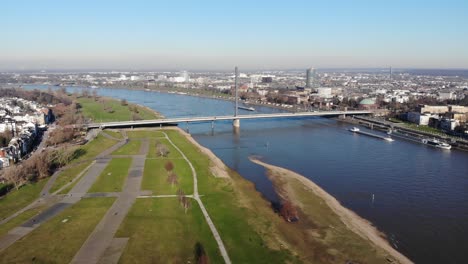 Drone-Footage-of-Duesseldorf-Oberkasseler-Bruecke,-Altstadt,-at-the-river-rhine,-in-sunny-winter-weather