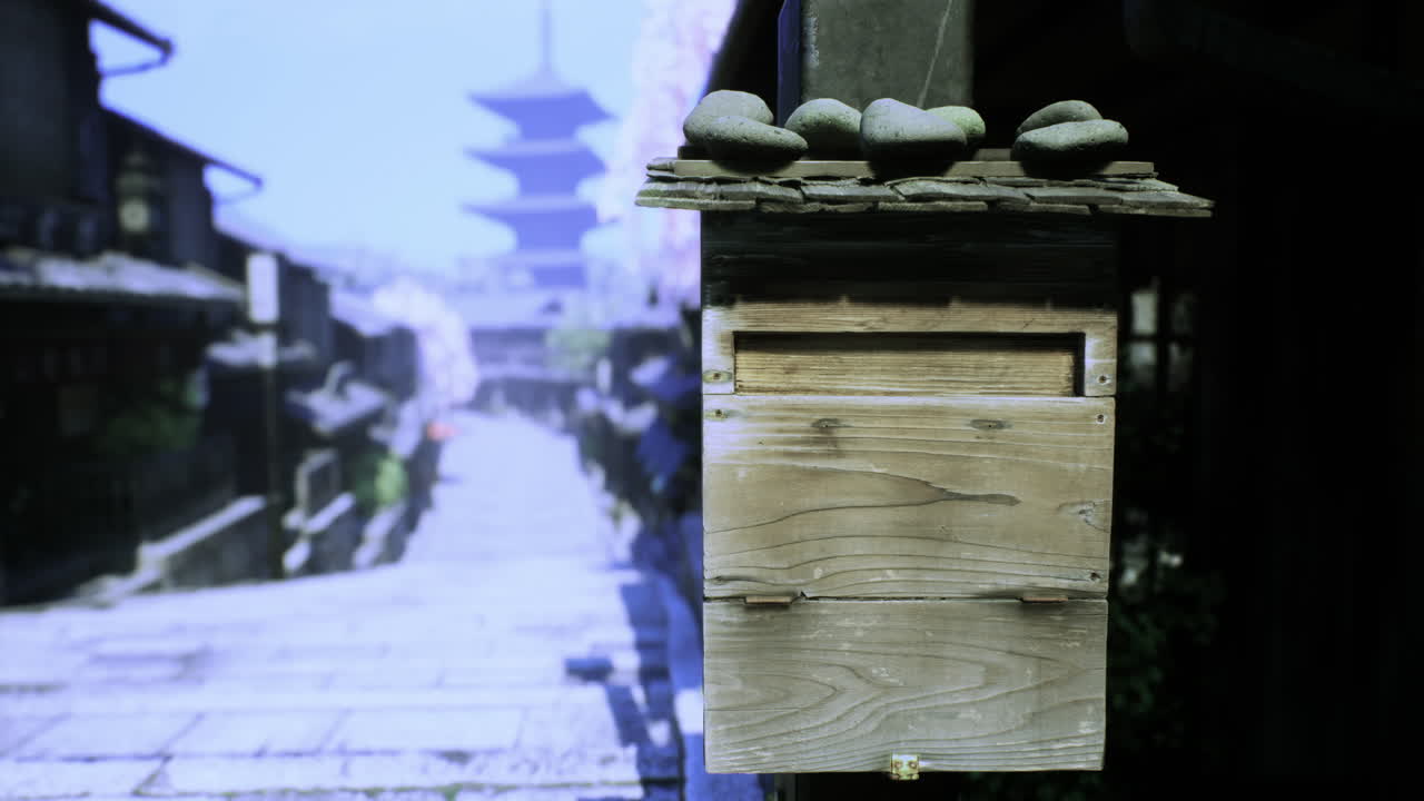 Old wooden mailbox beside cobblestone path with pagoda in background
