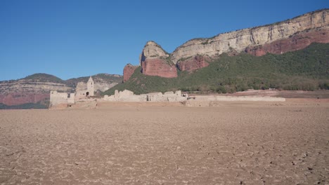 old buildings emerging from empty swamp due to the problems of extreme dryness and lack of rain