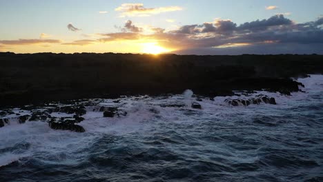 Dramatic Ocean Waves Crashing on Rocky Shore at Sunset