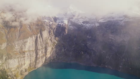 Vista-Aérea-Superior-Del-Lago-Oeschinen-En-La-Ladera-De-La-Montaña-En-La-Región-De-Los-Alpes-Suizos,-Paisaje-Del-Lago-Oeschinensee