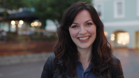 close-up-portrait-of-smiling-woman-laughing-cheerful-at-camera-enjoying-peaceful-urban-evening