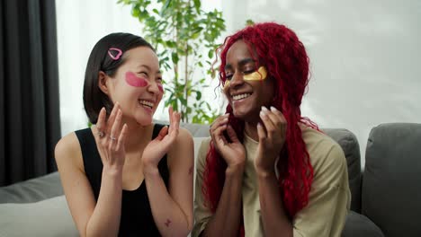 two young beautiful multiethnic women with patches under their eyes at home