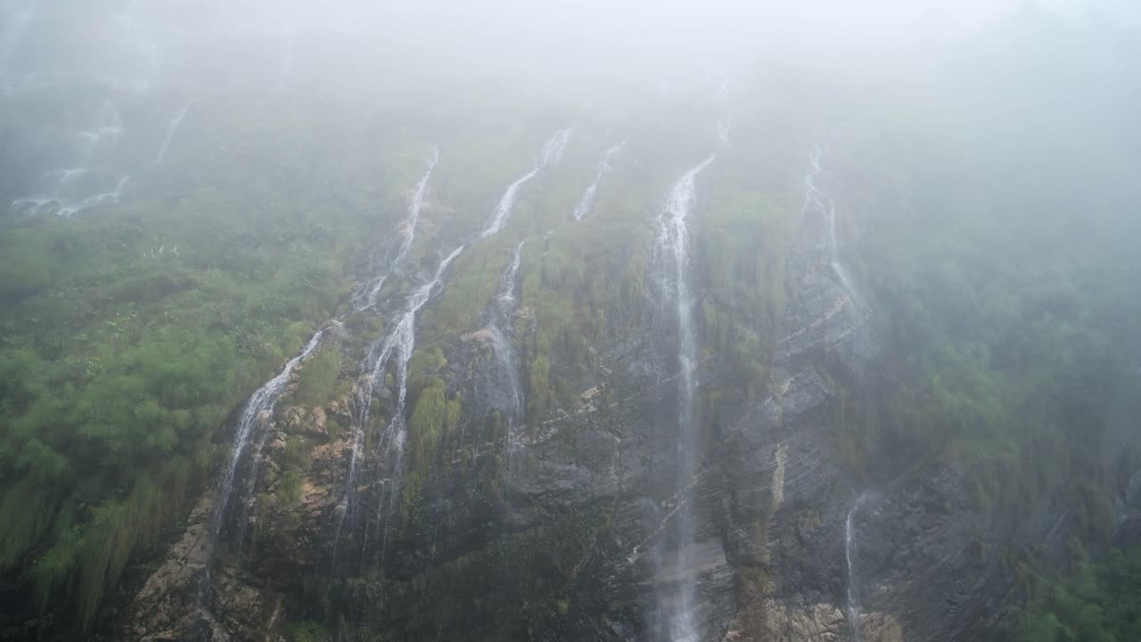 Misty Rugged Mountain Waterfall in Mist, Atmospheric Moody Waterfalls Falling off Rugged Rocks in the Himalayas Mountains in Nepal, Beautiful Scenery in Popular Famous Annapurna Trekking Area in Nepal