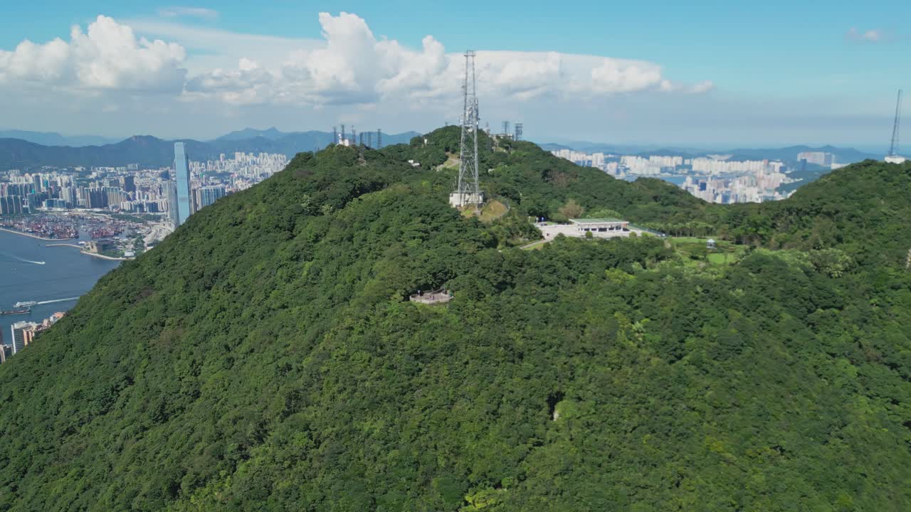Aerial drone footage capturing Victoria Peak and Hong Kong Harbour, showcasing panoramic city skyline, waterfront, and coastal scenery, highlighting urban architecture and iconic landmarks from above