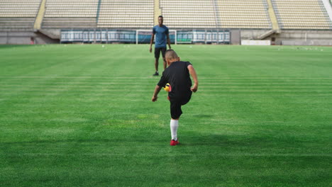 young boy practicing soccer with a coach at a stadium