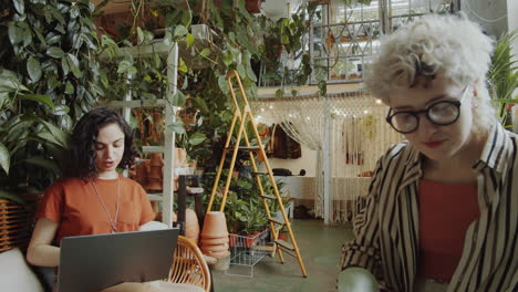 Young-Female-Colleagues-Working-on-Laptop-and-Planting-Flower