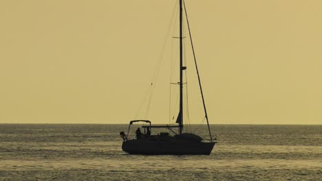 Velero-Al-Amanecer,-Yate-Recortado-En-El-Mar-Plateado,-Cámara-Lenta